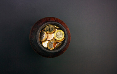 Photograph of a ceramic cube filled with coins.