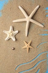 Beautiful starfishes and sand on blue background, flat lay