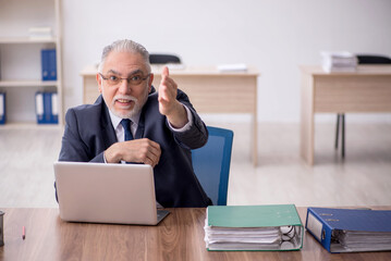 Old male employee working in the office