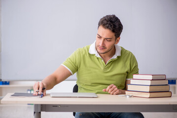Young male student sitting in the classroom