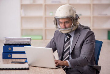 Young male employee wearing spacesuit in the office