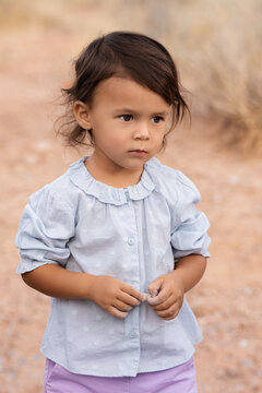 Little todder girl standing in desert, kids portrait and childhood memories concept