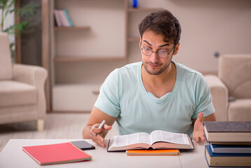 Young male student preparing for exams at home