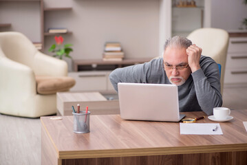 Obraz premium Old male employee working from home during pandemic