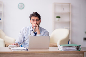 Fototapeta premium Young male employee working in the office