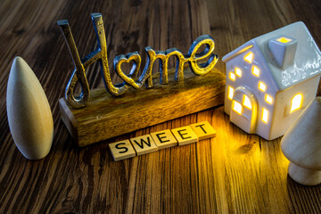 home sweet home sign ceramic house with bright wavy light on in the background
