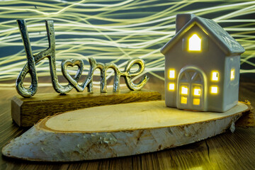 metal home sing ceramic house with bright wavy light on in the background