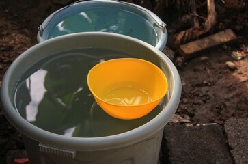 a bucket of water and a yellow dipper