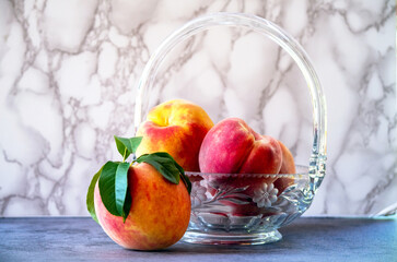 Peaches in a crystal bowl,  against marble background