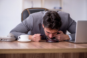 Young male drug addicted employee at workplace