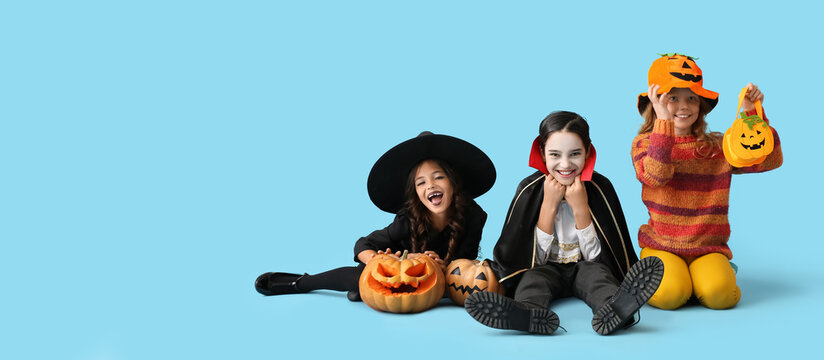 Little children in Halloween costumes on light blue background with space for text © Pixel-Shot