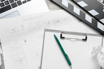 Clipboard with storyboard, laptop and movie clapper on grunge background