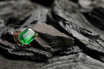 Golden ring on black charcoal, closeup