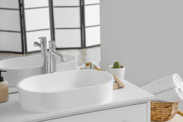 White sink with bath accessories on table in bathroom, closeup