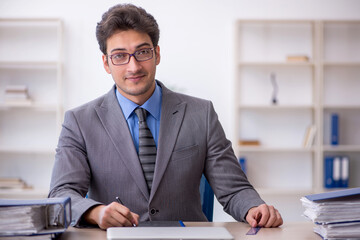 Obraz premium Young male employee working in the office