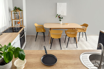 Interior of modern kitchen with wooden countertops and dining table