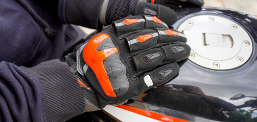 woman motorcyclist in motorcycle gloves on a motorcycle close-up