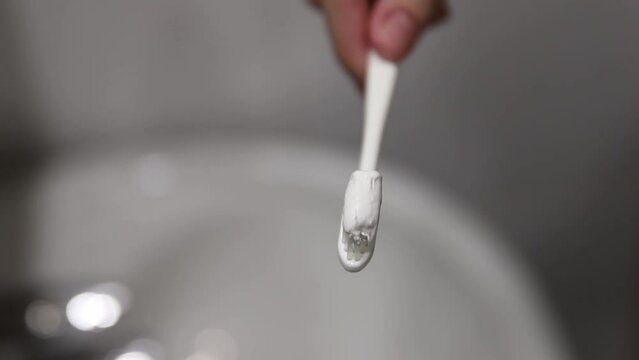 Squeezing toothpaste onto a toothbrush - A dental care moment.