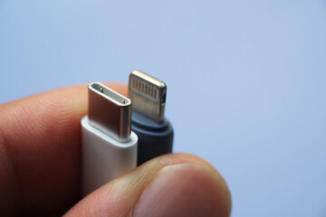 Close up USB Type C and Lightning charge head on a hand selective focus.