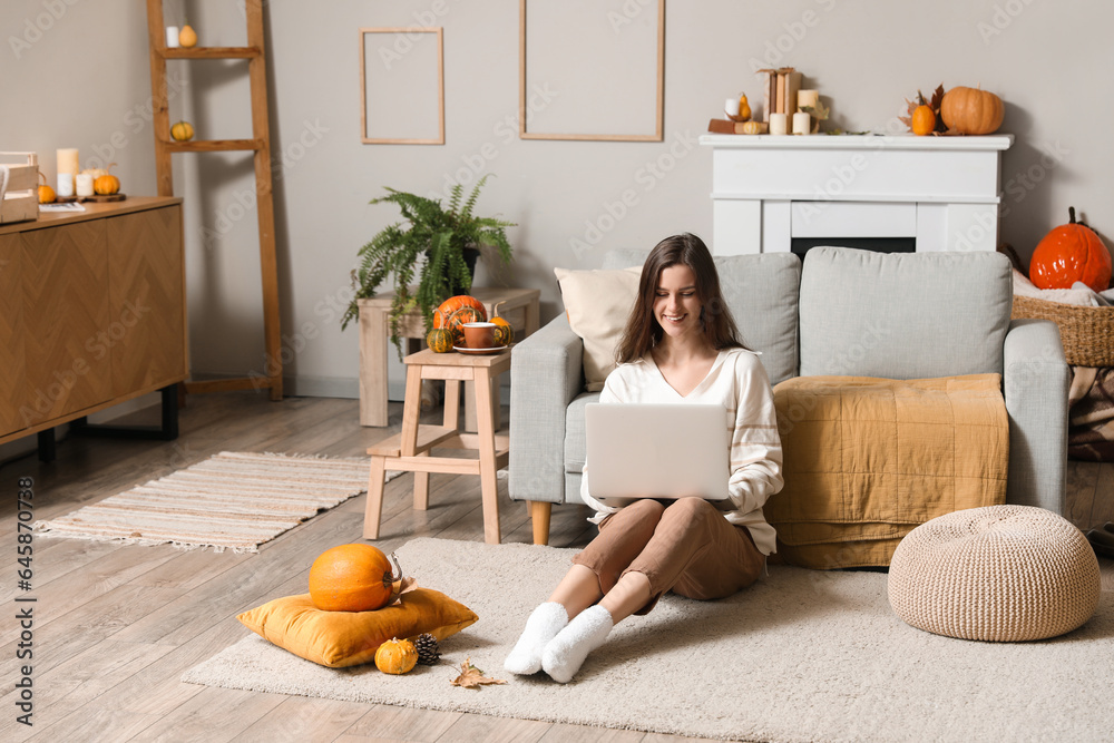 Wall mural young woman using laptop at home