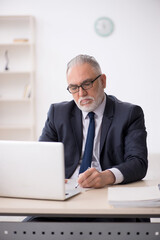Old male employee working in the office