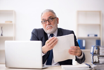 Old male employee working in the office