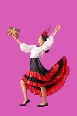 Young Asian woman dressed for Halloween with gift on pink background