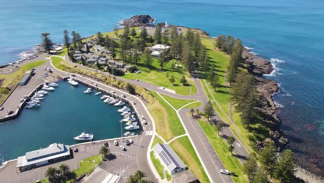 Aerial drone pullback reverse view of Kiama on the New South Wales South Coast, Australia showing Kiama Lighthouse and Harbour on a sunny day 