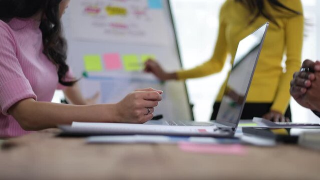 Meeting colleagues are discussing startup business strategy presentations and collaborative planning.