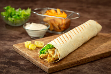 Tortilla wrap with chicken breast, vegetables and lettuce with curry mixture