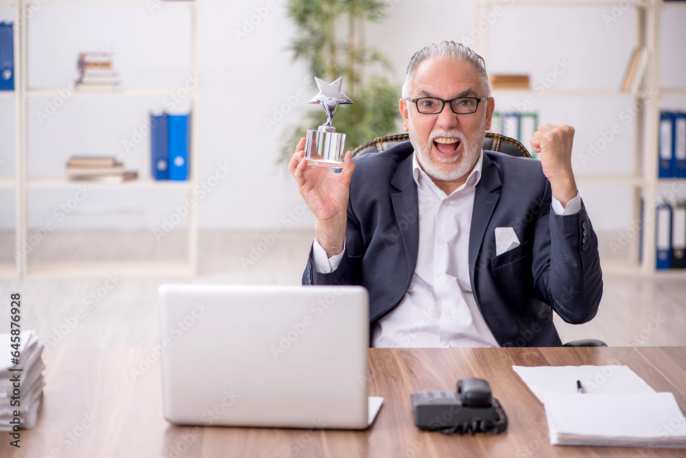 Wall mural old male employee holding star award