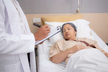 Obraz premium Doctor checkup and diagnostic with patient elderly woman for prescription or planning rehabilitation at hospital, physician talking with patient and writing document, medical and insurance concept.