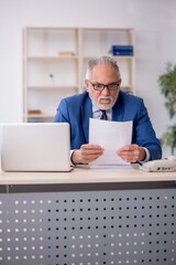 Old male employee working in the office