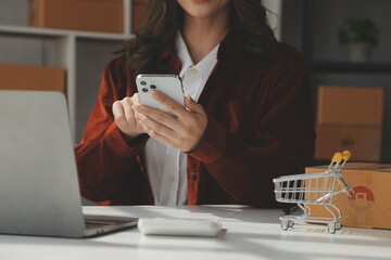 Portrait young attractive hipster asia female owner startup look at camera work happy with box at home prepare parcel delivery in sme supply chain, procurement, omnichannel ecommerce online concept.