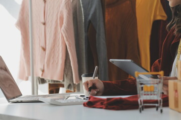 Fototapeta premium Portrait young attractive hipster asia female owner startup look at camera work happy with box at home prepare parcel delivery in sme supply chain, procurement, omnichannel ecommerce online concept.