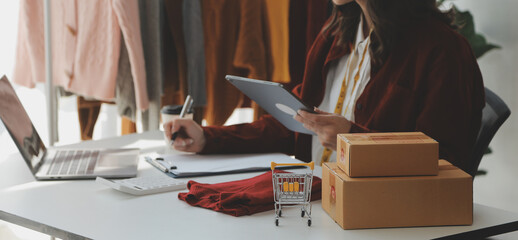 Portrait young attractive hipster asia female owner startup look at camera work happy with box at home prepare parcel delivery in sme supply chain, procurement, omnichannel ecommerce online concept.