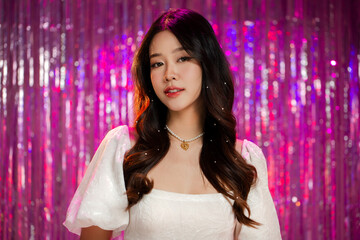 Beautiful young Asian girl with K-beauty make up on vivid glitter lights bokeh background. Glamour...