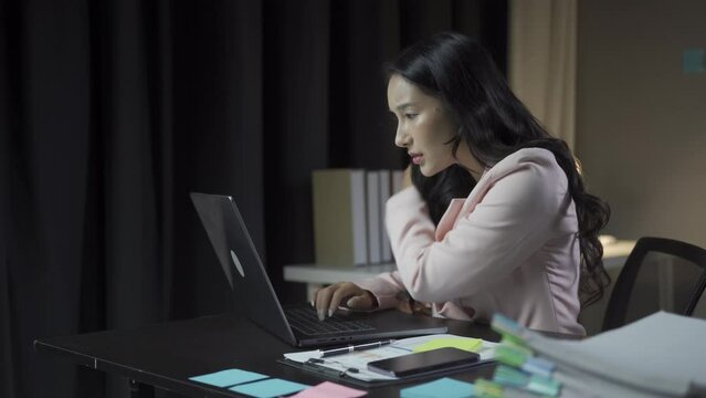 Asian businesswoman has arm pain, shoulder pain, neck pain and stress and fatigue from working on laptop for a long time she has office syndrome, work concept.