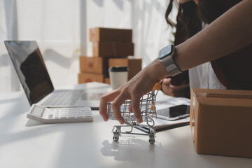 Portrait young attractive hipster asia female owner startup look at camera work happy with box at home prepare parcel delivery in sme supply chain, procurement, omnichannel ecommerce online concept.