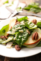 Mixed salad with spinach, apple, pecan nut and parmesan