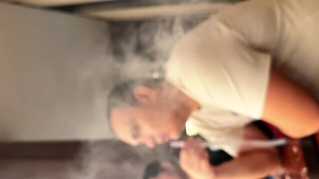 man smoking hookah in a bar. High quality FullHD footage