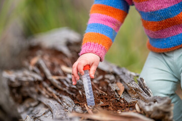 child doing science, toddler with test tubes outside in natural