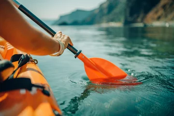 Foto op Canvas Kayak paddle sea vacation. Person paddles with orange paddle oar on kayak in sea. Leisure active lifestyle recreation activity rest tourism travel © svetograph