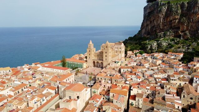 Cefalu, Italy: Aerial drone footage of the Cefalu medieval old town, famous for its Norman cathedral and cliff near Palermo in Sicily. Shot with a tilt down motion. 