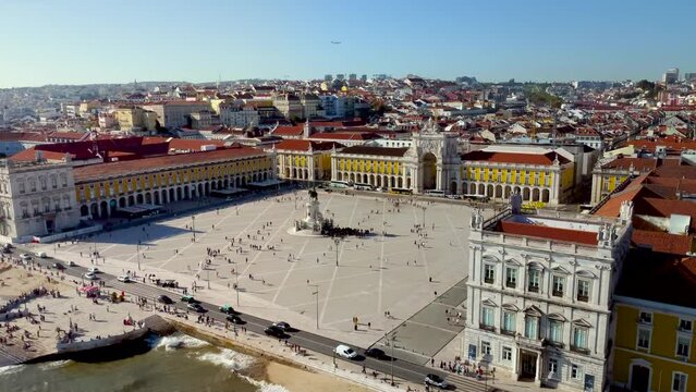 Cinematic aerial view of Lisbon city - Portugal. View of "Pra&ccedil;a do Com&eacute;rcio" - Commerce Square in the city center. In front of the square is the river Tagus with promenade area and port. Travel.