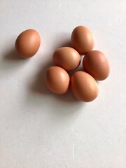Light brown chicken eggs on white background.