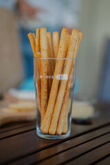 Tasty italian bread sticks and olives snacks on picnic wooden table