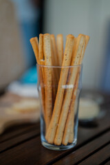 Tasty italian bread sticks and olives snacks on picnic wooden table
