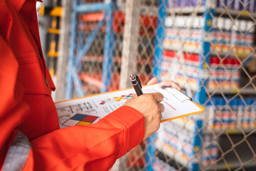 A worker is checking on the hazardous chemical material information form with background of chemical storage area at the factory place. Industrial safety working action. Selective focus.	
 - obrazy, fototapety, plakaty