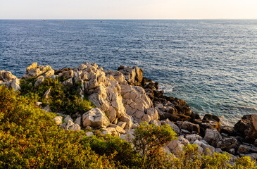 Rocks and cliffs shoreline sunset landscape of Cap Ferrat cape hosting Saint-Jean-Cap-Ferrat resort...